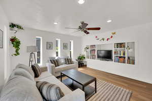 Living room featuring wood finished floors, a ceiling fan, recessed lighting, and baseboards