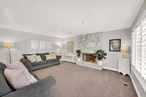 Living room featuring carpet floors, baseboards, and a fireplace