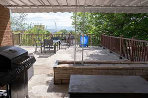 View of patio / terrace with grilling area, outdoor dining space, and a wooden deck