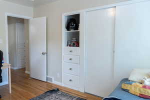 Bedroom featuring wood finished floors, baseboards, and an office area