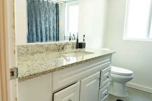 Bathroom with vanity, tile patterned floors, toilet, a shower with shower curtain, and baseboards