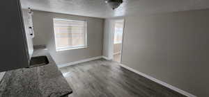 Dining area featuring a textured ceiling, wood finished floors, and baseboards