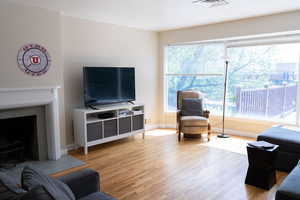 Living area with light wood finished floors, baseboards, and a fireplace