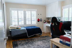Bedroom featuring wood finished floors and baseboards