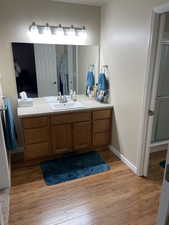 Bathroom with visible vents, vanity, a shower stall, wood finished floors, and baseboards