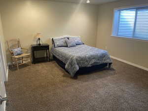 Bedroom featuring dark carpet and baseboards