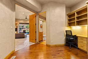 Office with hardwood / wood-style floors, ceiling fan, built in desk, and recessed lighting