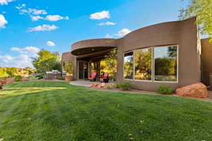 Back of house with a patio area, a yard, stucco siding, and exterior kitchen
