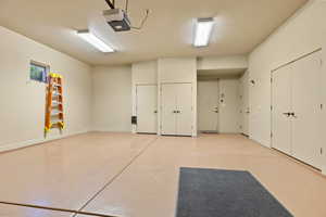 Garage with a garage door opener and baseboards