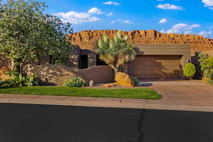 View of front of house with a garage, concrete driveway, a mountain view, and stucco siding