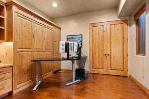 Unfurnished office featuring dark wood finished floors and baseboards