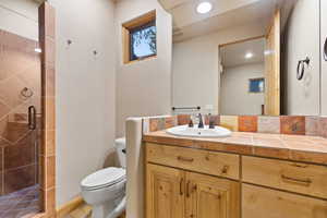 Bathroom with a shower stall, vanity, and recessed lighting