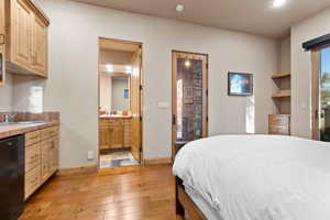 Bedroom with light wood-type flooring, recessed lighting, and ensuite bathroom