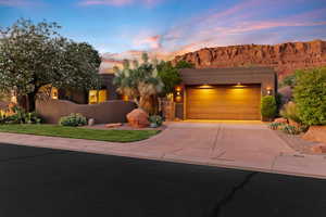 Pueblo revival-style home featuring driveway, a garage, a mountain view, and stucco siding