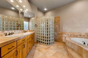 Bathroom with a bath, double vanity, recessed lighting, and walk in shower