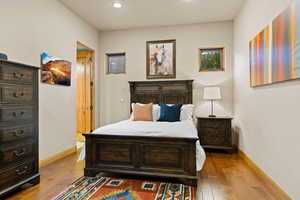 Bedroom with dark wood-style floors and recessed lighting