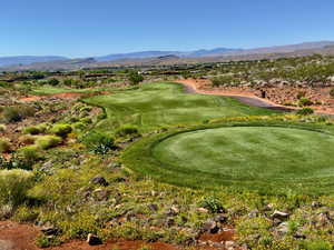 View of home's community with a putting area, a mountain view, and view of golf course