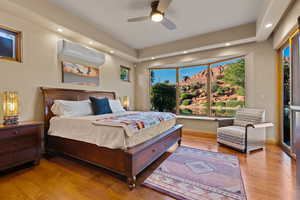 Bedroom featuring recessed lighting, hardwood / wood-style floors, an AC wall unit, access to exterior, and ceiling fan