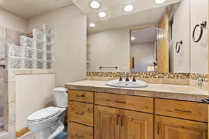 Full bathroom featuring vanity, walk in shower, decorative backsplash, and recessed lighting