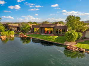 Back of property with a lawn, stucco siding, and a patio