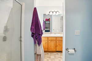 Full bath featuring a stall shower and vanity