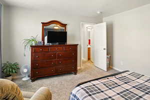 Bedroom featuring light carpet and baseboards