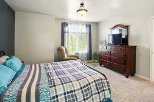 Bedroom with light colored carpet and baseboards