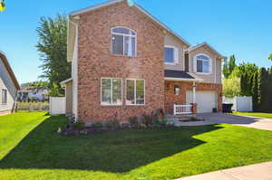 Traditional home with an attached garage, concrete driveway, and brick siding