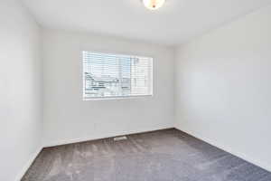 Carpeted empty room featuring baseboards