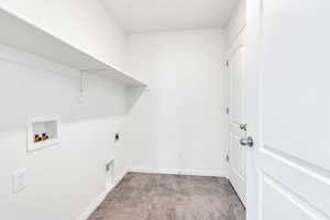 Washroom with hookup for an electric dryer, washer hookup, and baseboards