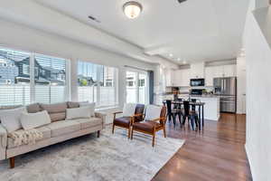 Living room featuring dark wood-style flooring, recessed lighting, and baseboards