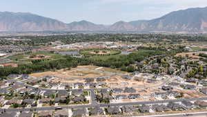 Aerial view of property and surrounding area featuring mountains and nearby suburban area