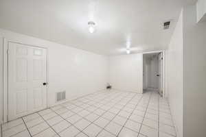 Spare room featuring light tile patterned floors and baseboards