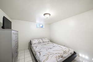 Bedroom featuring light tile patterned floors and baseboards