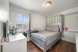Bedroom with wood finished floors and baseboards