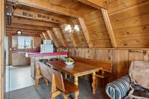 Dining space featuring wooden ceiling, a chandelier, and wood walls