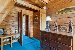 Carpeted bedroom with wood walls