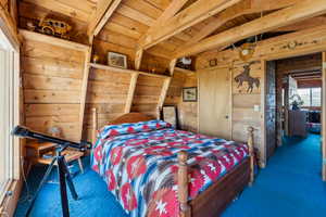 Bedroom with carpet flooring and wood walls