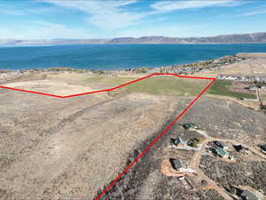 Aerial view of property and surrounding area with a water and mountain view and property parcel outlined