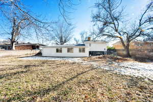Rear view of property featuring a chimney