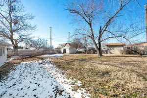 Snowy yard with a fenced backyard and an outdoor structure