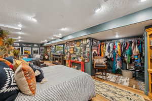 Bedroom with wood finished floors and a textured ceiling