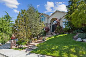 View of front of property featuring stucco siding and a front yard