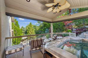 Wooden deck featuring a ceiling fan and view of wooded area
