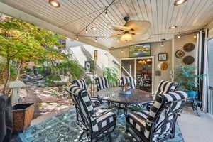 View of patio with outdoor dining area and ceiling fan