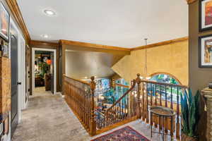 Stairs featuring crown molding, a chandelier, baseboards, and recessed lighting