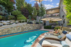 Outdoor pool with stairway, an outdoor living space, and a patio