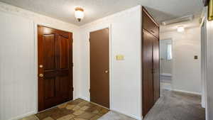 Entryway featuring a textured ceiling and baseboards