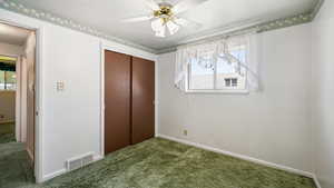 Unfurnished bedroom with carpet floors, a closet, baseboards, and a ceiling fan