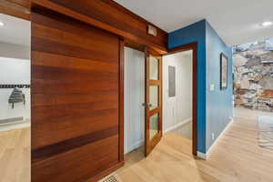 Hall featuring light wood-style flooring, baseboards, and recessed lighting
